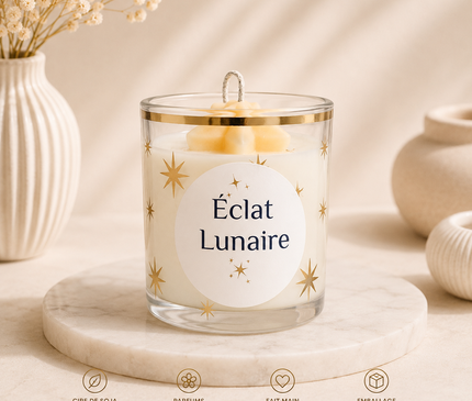 Bougie parfumée Éclat Lunaire aux notes fruitées, florales, ambrées et vanillées avec paillettes d'or dans un contenant en verre écologique