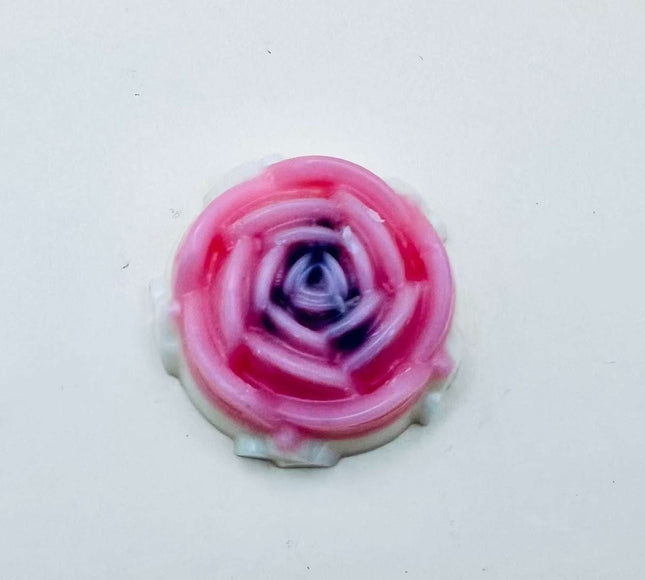 Fondant Améthyste en forme de rose, aux pétales roses et au cœur violet foncé, en cire lisse.