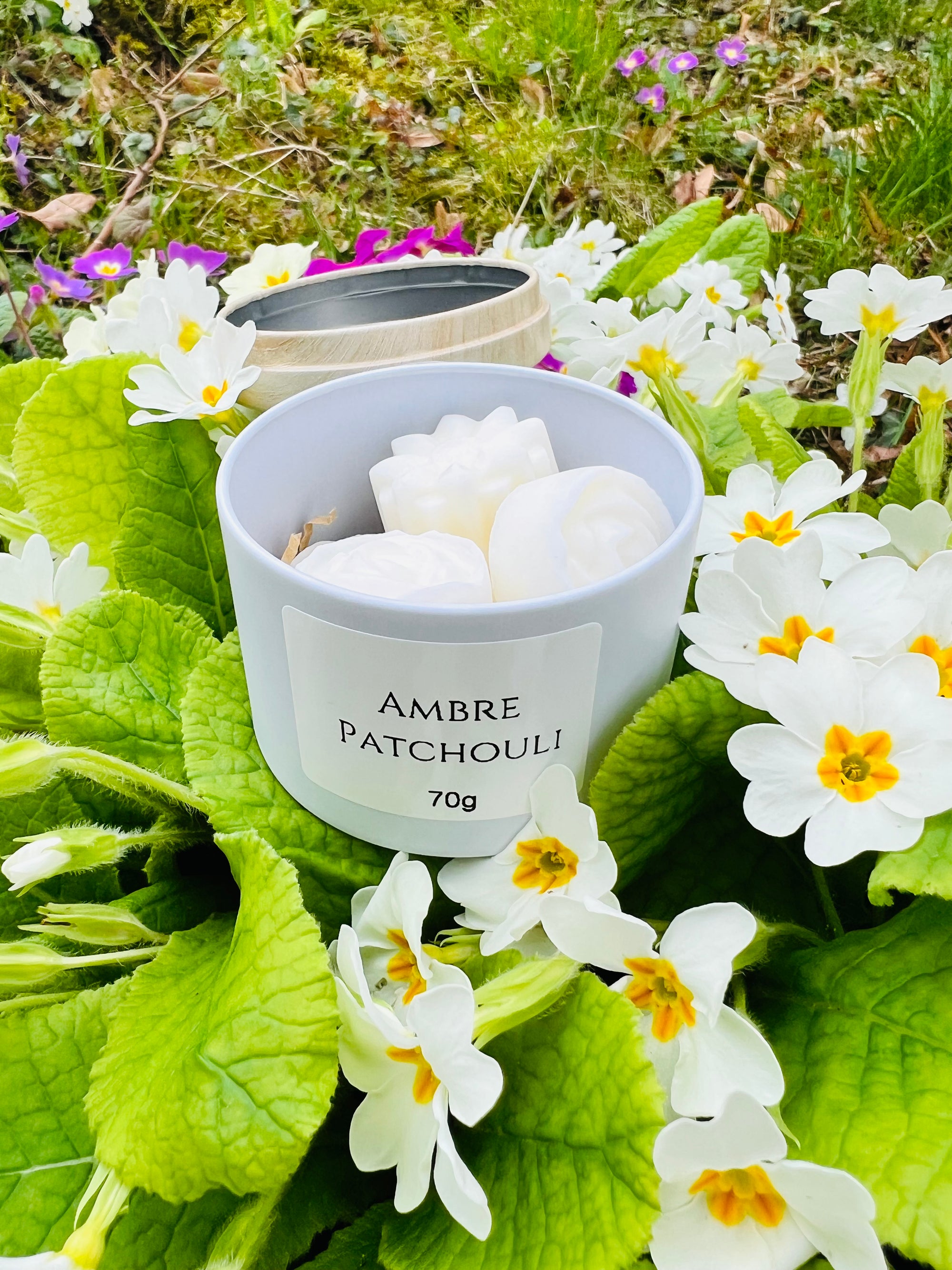 Emballage des fondants parfumés Ambre Patchouli de Onéotéa - Éveil des Sens, illustrant le produit dans son contenant, mettant en avant les notes de fondant parfumé. Ce concept évoque la Résilience, offrant une transformation olfactive avec des ingrédients tels que la cire de soja et le parfum de Grasse.