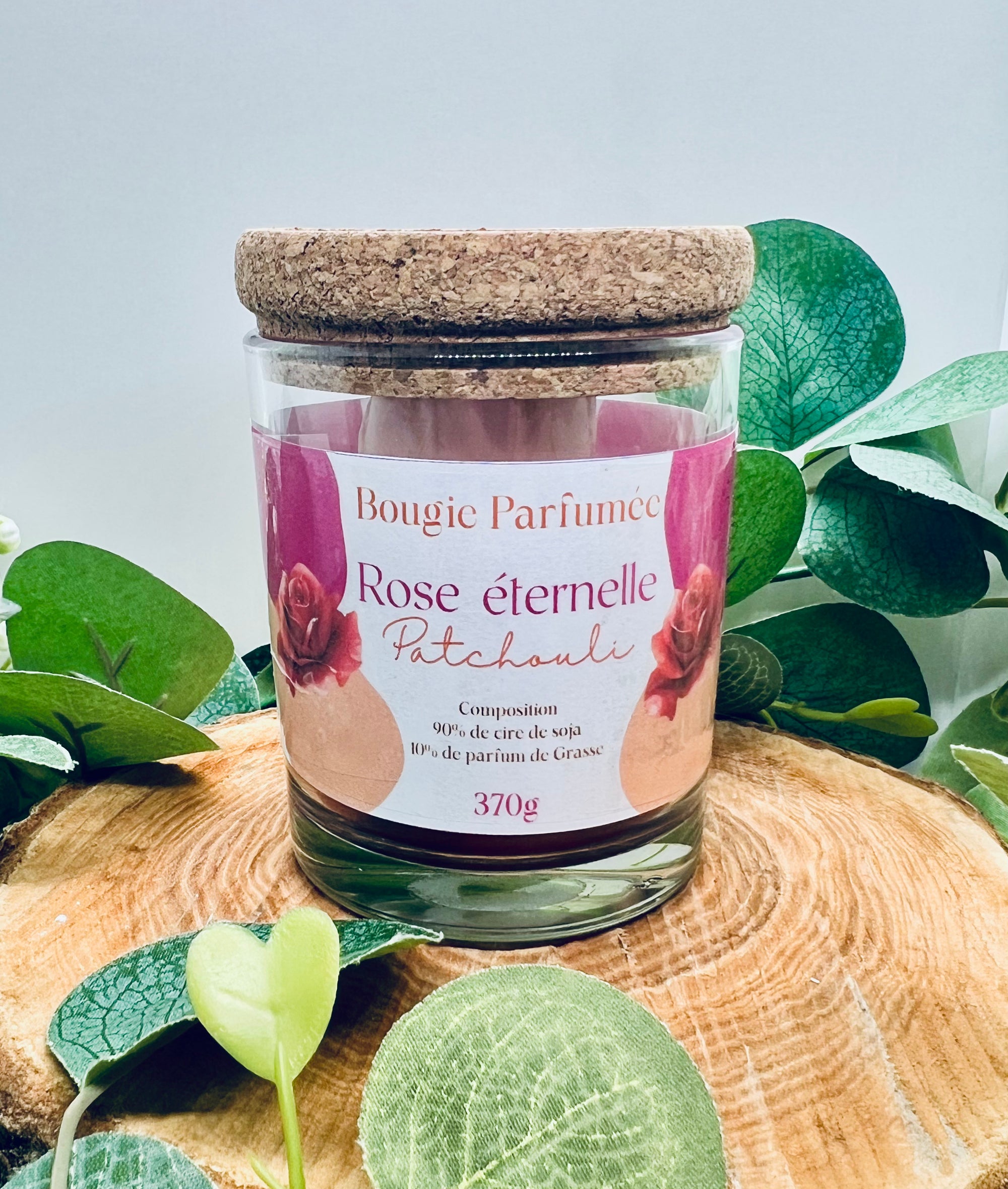 Bougie parfumée artisanale Ambre Patchouli & Rose éternelle by Onéotéa - Éveil des Sens sur un fond en bois, mettant en avant son verre élégant et son couvercle en liège.