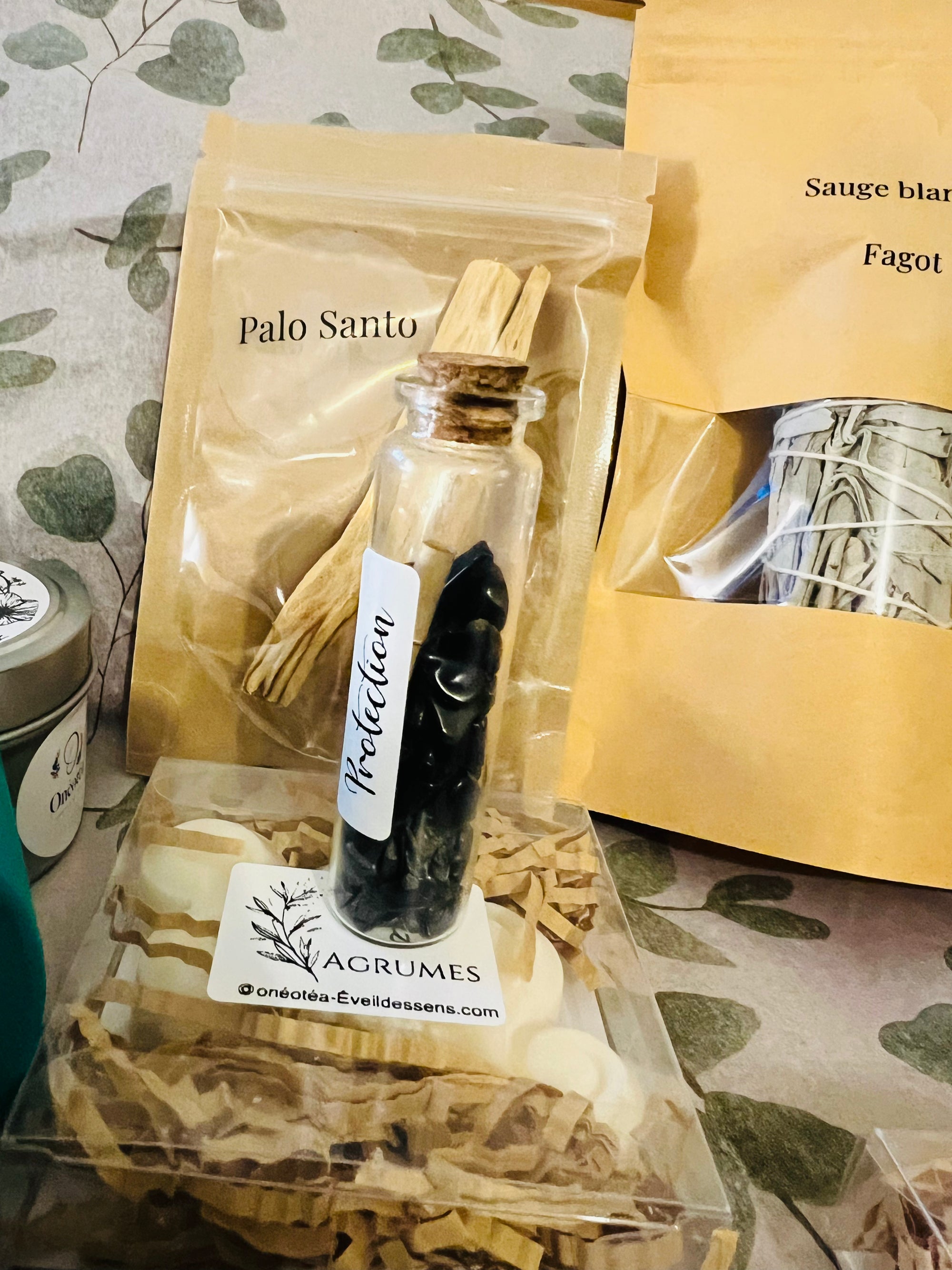 Zoom sur le contenu de la Box Purification Énergétique d'Onéotéa, avec Palo Santo, un flacon de protection et d'autres produits purifiants.
