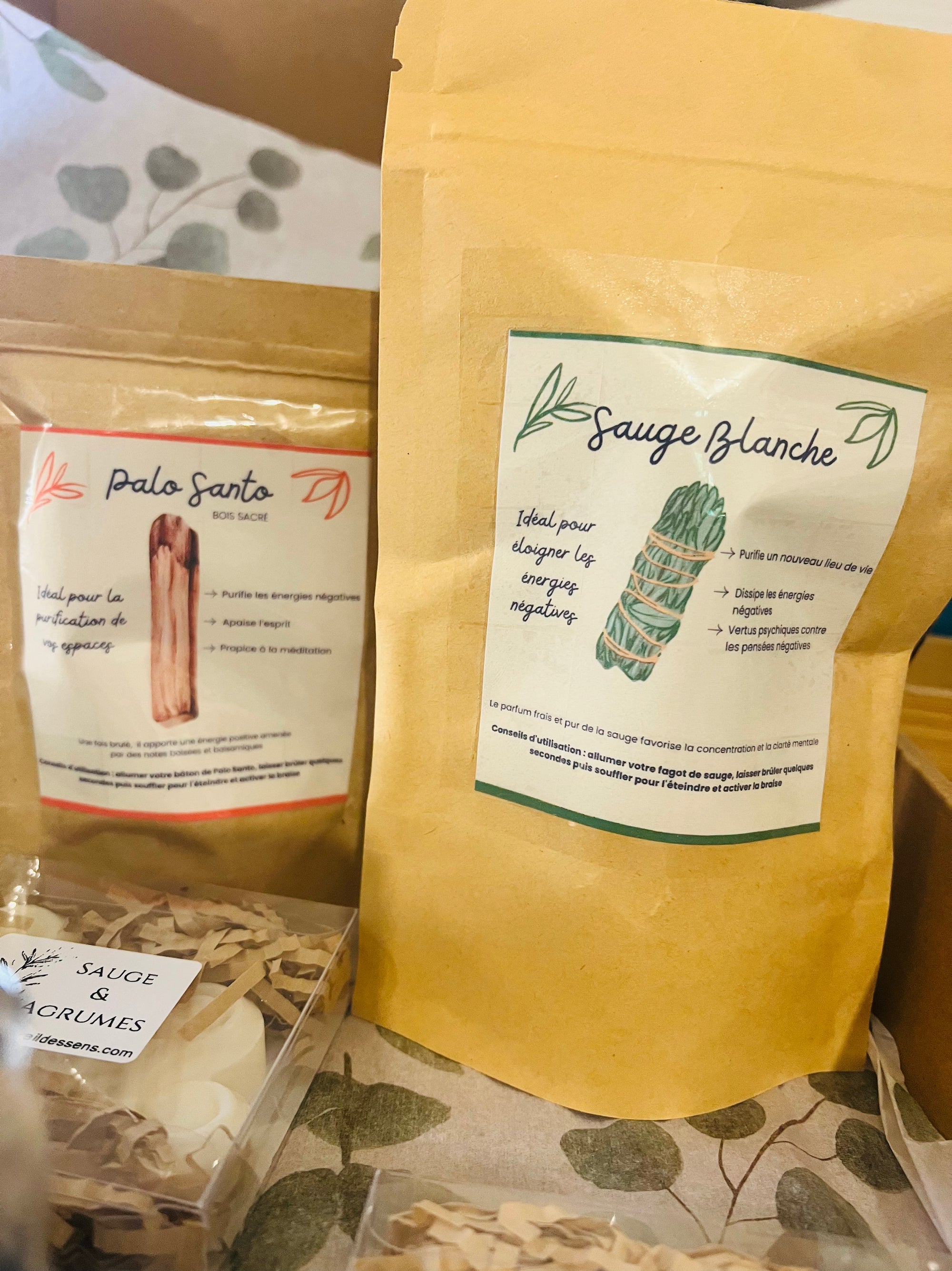 Les trésors de la Box Purification Énergétique d'Onéotéa, incluant des Palo Santo et des sachets de Sauge blanche, pour éloigner les énergies négatives.